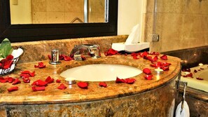 A bathroom with a marble sink, a mirror, and a bathtub. - Hotel Verdi (San Juan Bautista Tuxtepec)