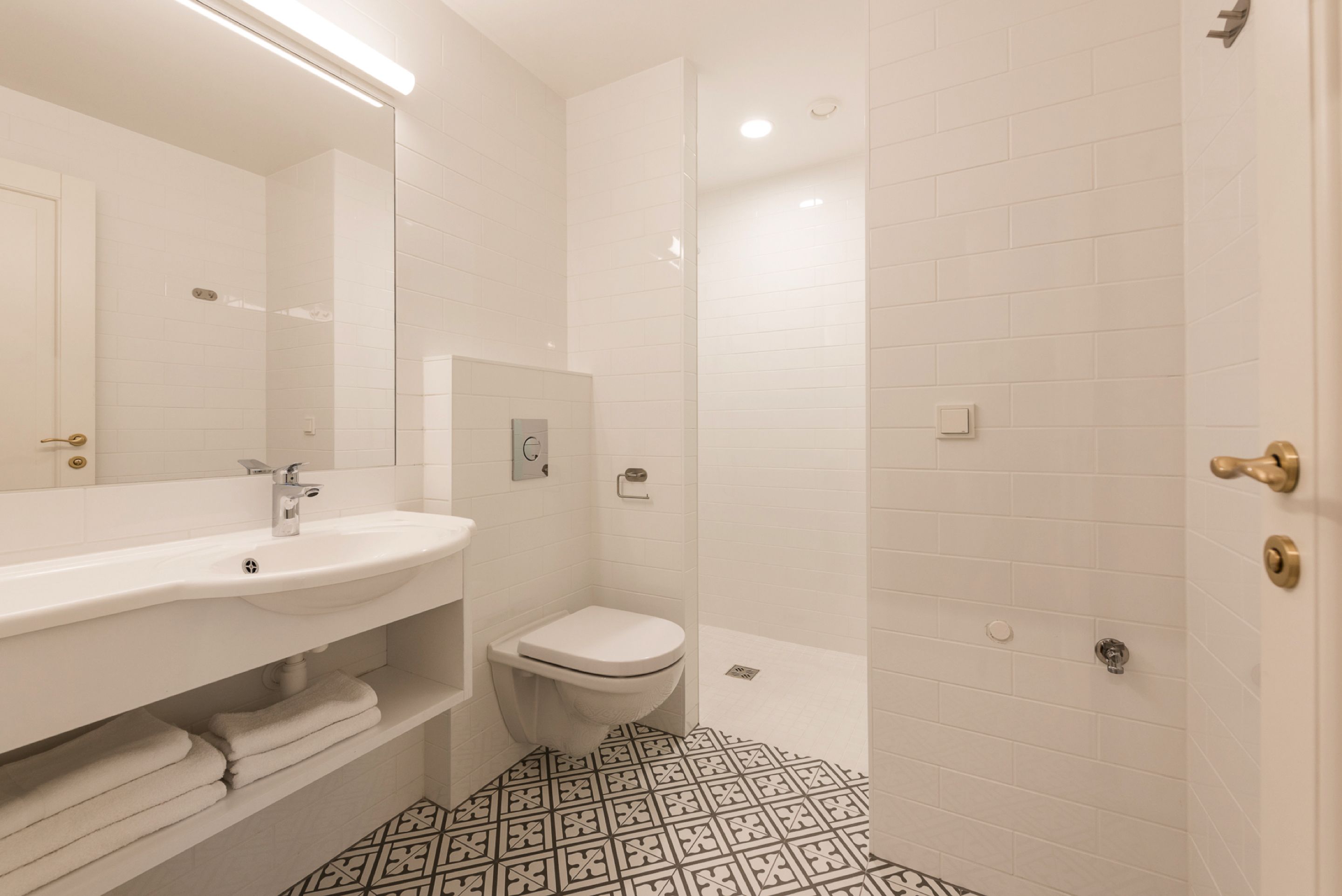 Ein Badezimmer mit weißem Waschbecken, Toilette und Duschbereich.