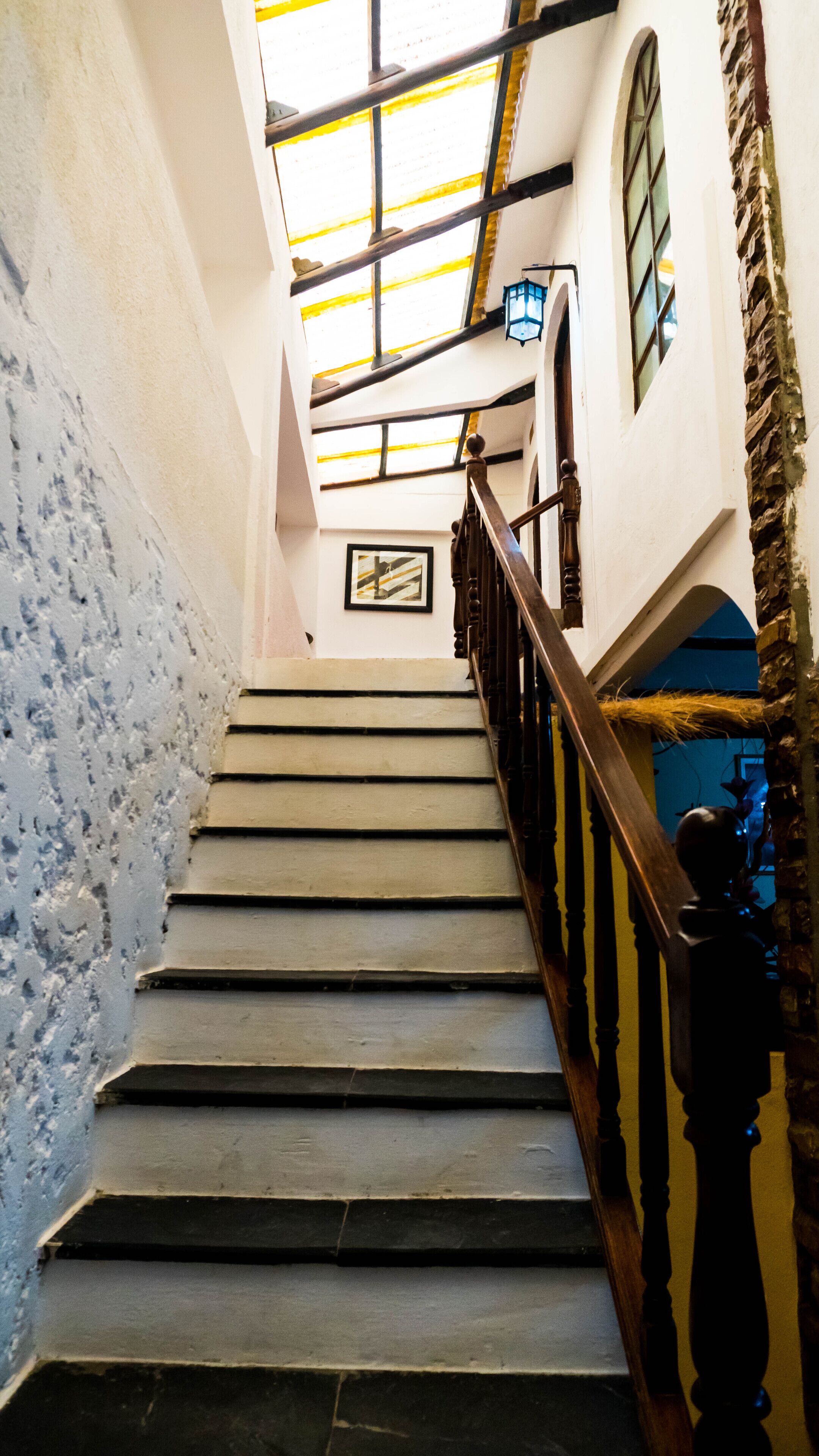 A staircase with wooden balusters and a stone wall on one side.