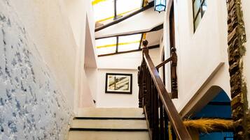 A staircase with wooden balusters and a stone wall on one side.