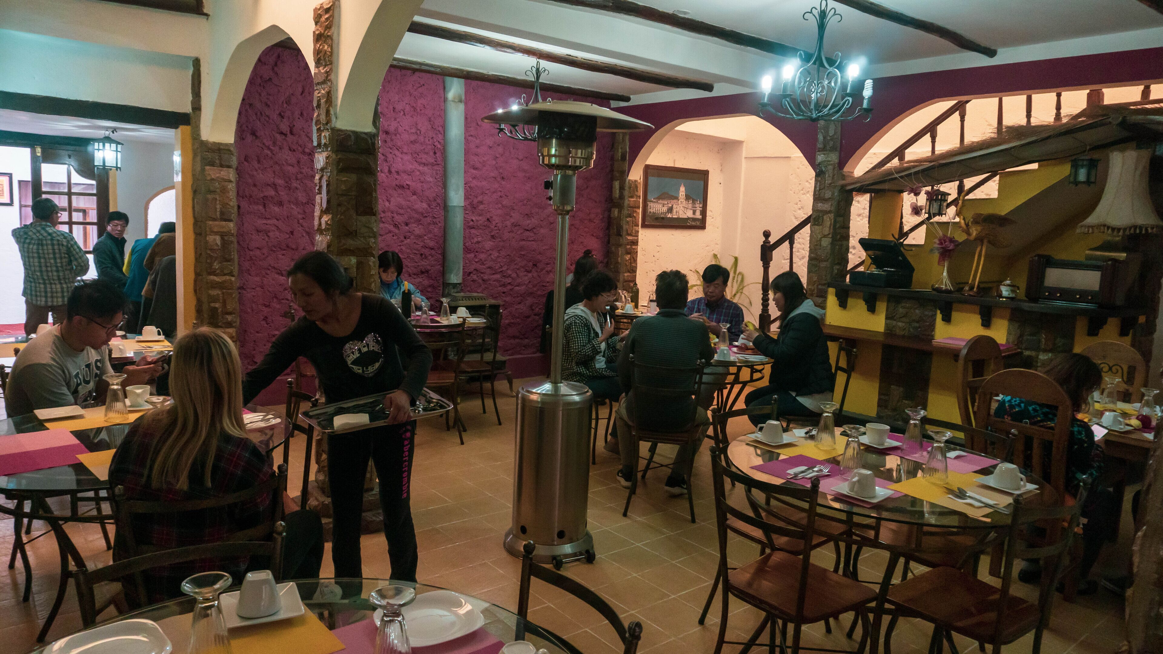 A restaurant interior with tables, chairs, and patrons.
