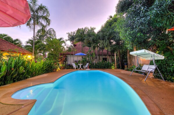 Alberca al aire libre y camastros 