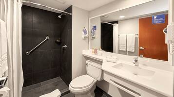 A modern bathroom with a shower, toilet, and sink.