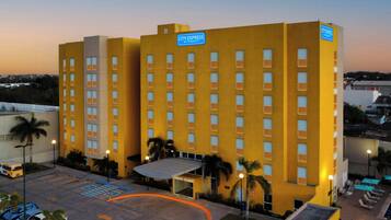 Un hotel de varios pisos con techo plano, estacionamiento y un letrero que indica que es un hotel Marriott.