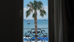 A window with a view of a palm tree and the sea. - Artemis Hotel (Bodrum)