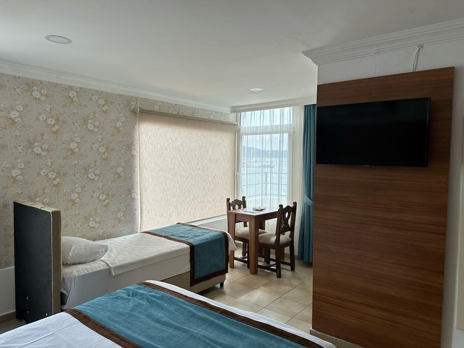 Una habitación de hotel con dos camas, un escritorio y un televisor.
