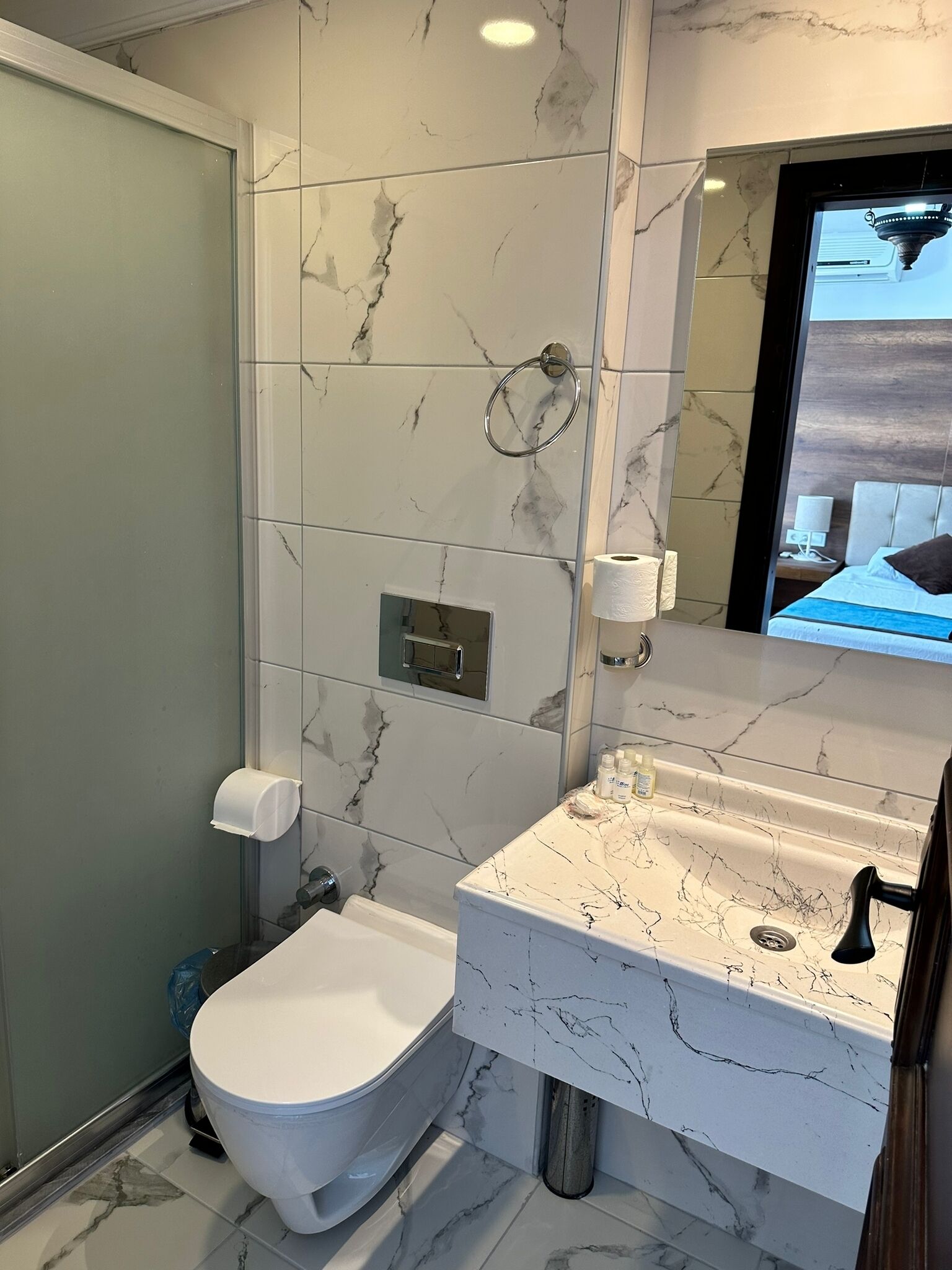A modern bathroom with a toilet, sink, and shower.