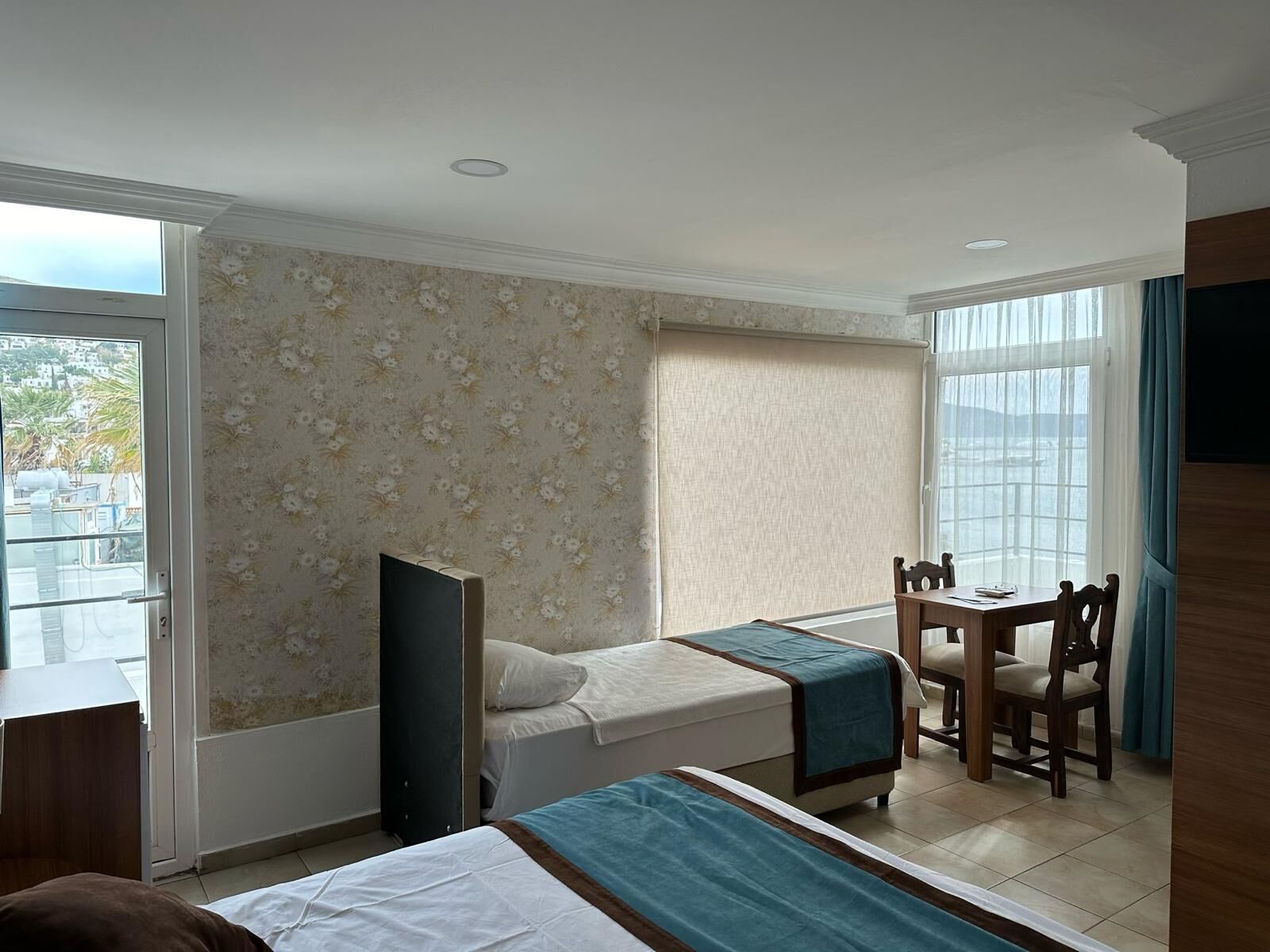 A hotel room with two beds, a desk, and a chair.