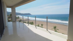 Un balcón con vista a la playa y al océano.
