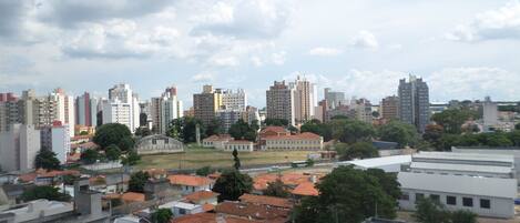 A cityscape with a mix of residential and commercial buildings, including a prominent white building with a dome structure in the center.