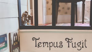 Una stanza con una porta bianca, una finestra e un muro decorato con diverse foto incorniciate.