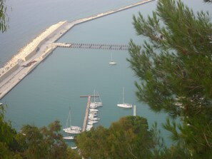 Un port de plaisance avec des bateaux amarrés, une digue et une jetée qui s’avance dans l’eau.