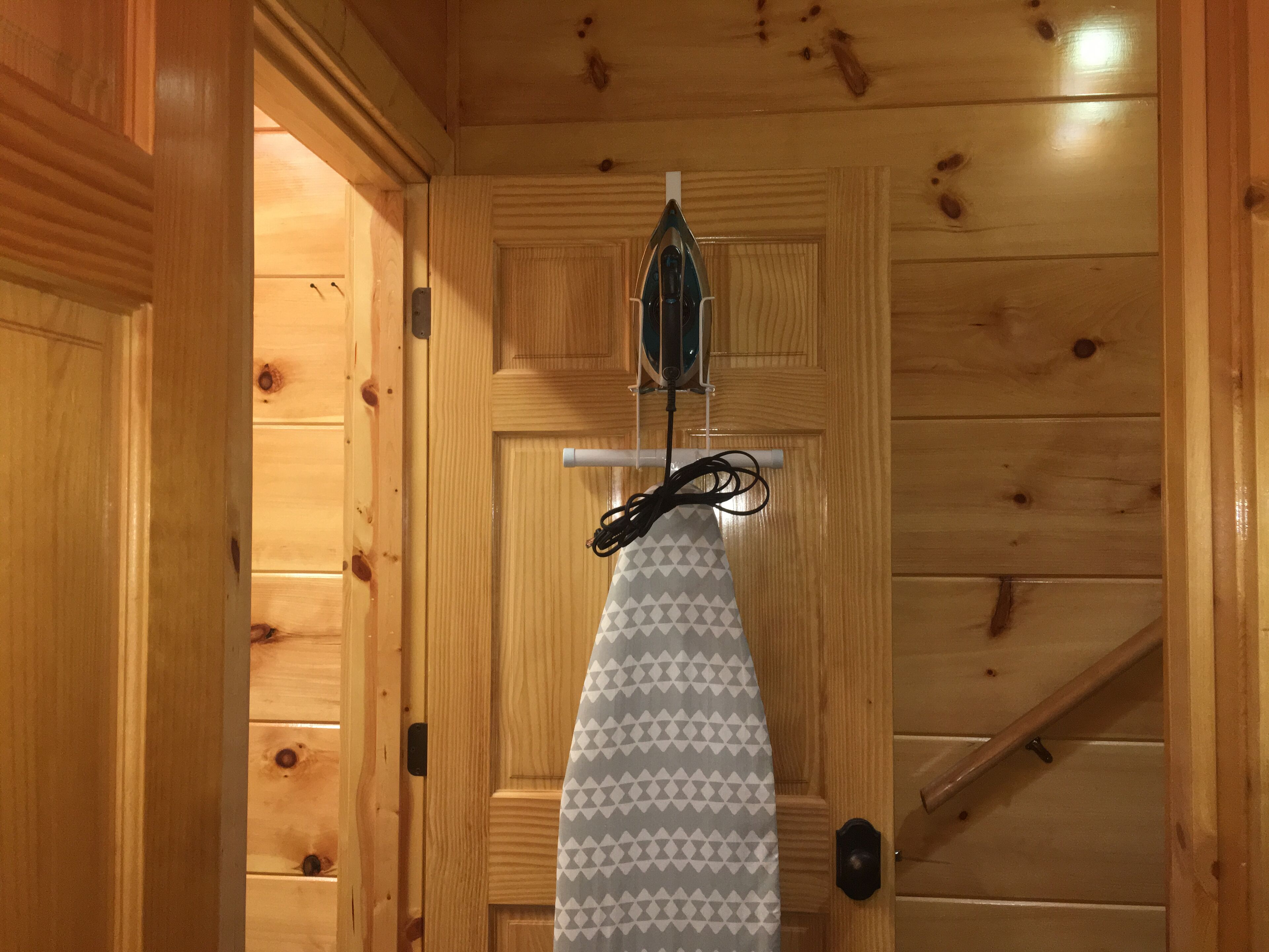 A wooden door with a hanging iron tool and a patterned cloth.