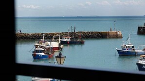 A harbor with several boats docked near a stone pier. - Rocksalt (Folkestone)