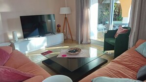 A living room with a flat-screen TV, a lamp, a coffee table, and a sofa.