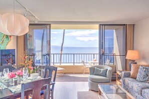 Ein modernes Hotelzimmer mit Balkon, Essbereich und Sitzecke mit Meerblick.