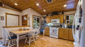 Eine Küche mit Holzausstattung, einem weißen Herd und einem Kühlschrank.