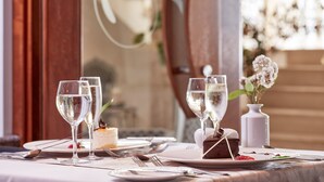 A table set for a meal with wine glasses, plates, and a dessert. - Atlantica Golden Beach -Adults Only (Kissonerga)