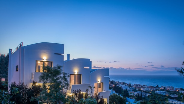 A modern coastal building with multiple balconies and a view of the sea.