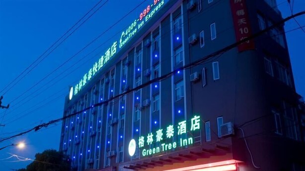 A hotel with multiple floors and a prominent Green Tree Inn sign.