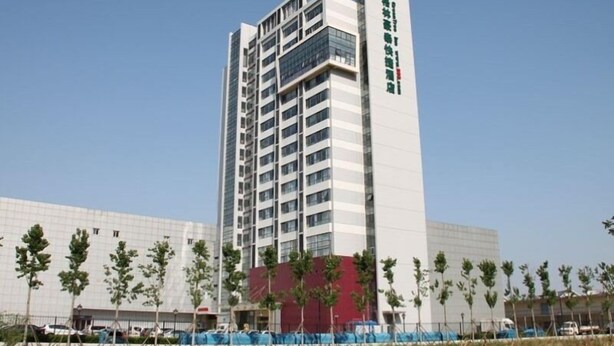 A tall, modern hotel building with a prominent vertical sign on the right side. - GreenTree Inn TianJin JinNan ShuangLin Metro Station Express Hotel (Tianjin)