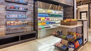 A grocery store with shelves stocked with snacks, beverages, and packaged goods. - Cambria Hotel New Orleans Downtown Warehouse District (New Orleans)