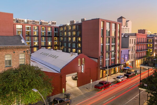 A multi-story building with a red facade, large windows, and a flat roof. - Cambria Hotel New Orleans Downtown Warehouse District (New Orleans)