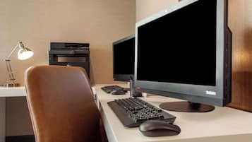 A workspace with a desk, two monitors, a keyboard, a mouse, a lamp, and a printer.
