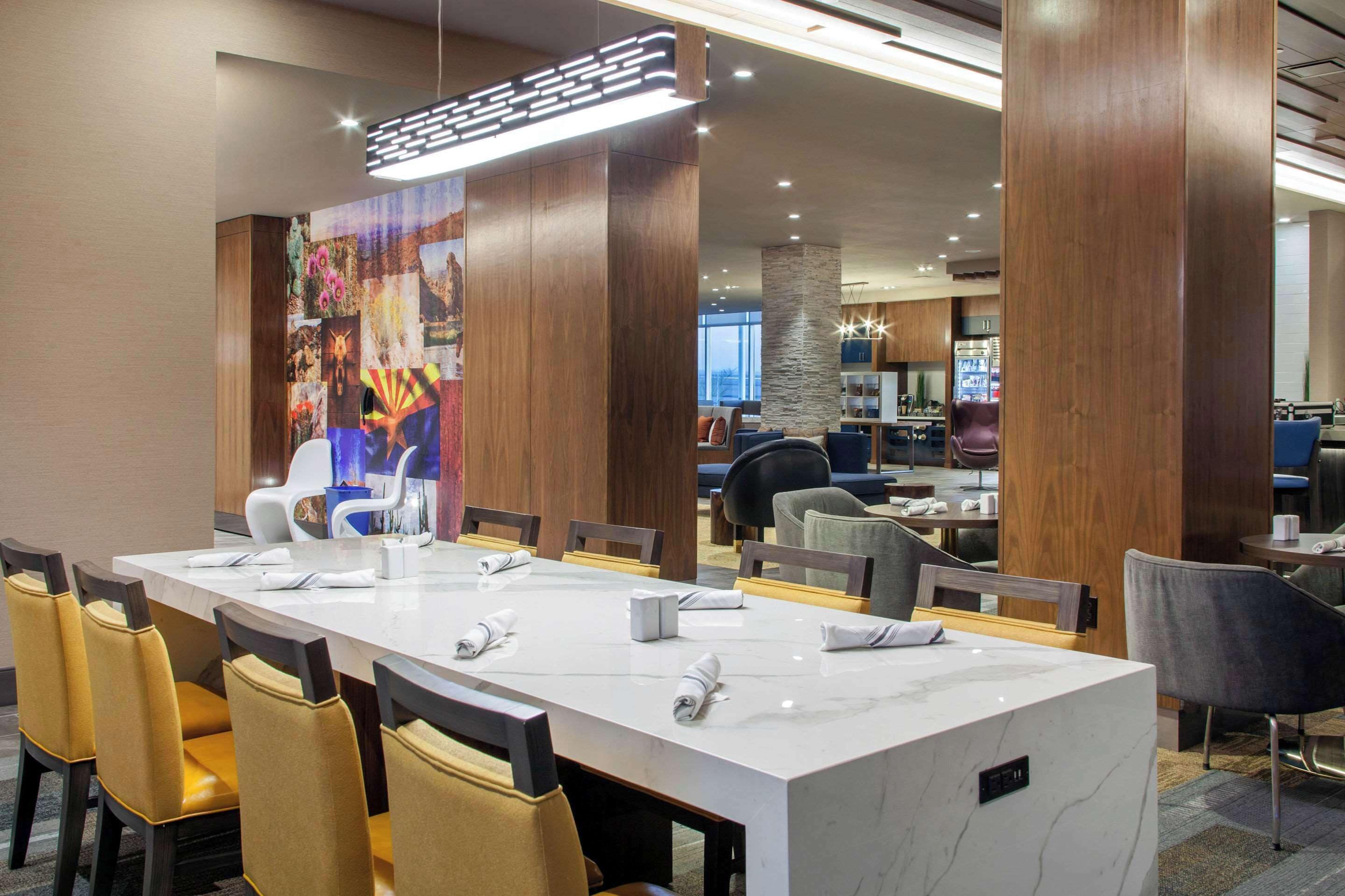 A conference room with a long table, chairs, and a large decorative panel.