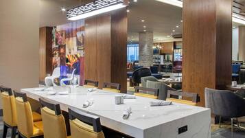 A conference room with a long table, chairs, and a large decorative panel.