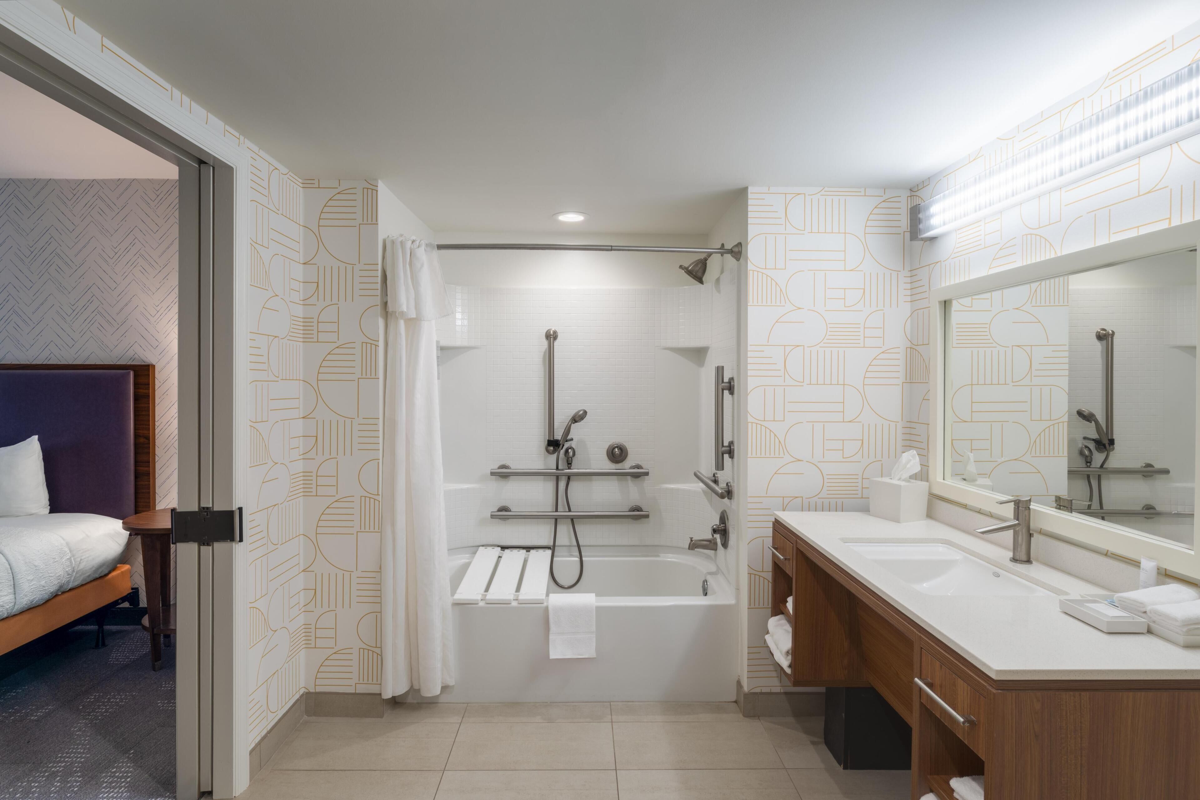 Un baño moderno con bañera, ducha y lavamanos doble.