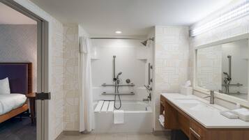Un baño moderno con bañera, ducha y lavamanos doble.