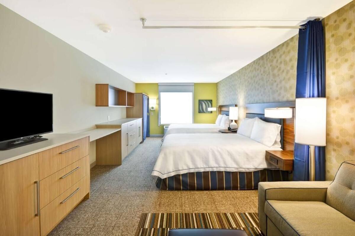 Une chambre d’hôtel avec un lit, une télévision, un bureau et une chaise.