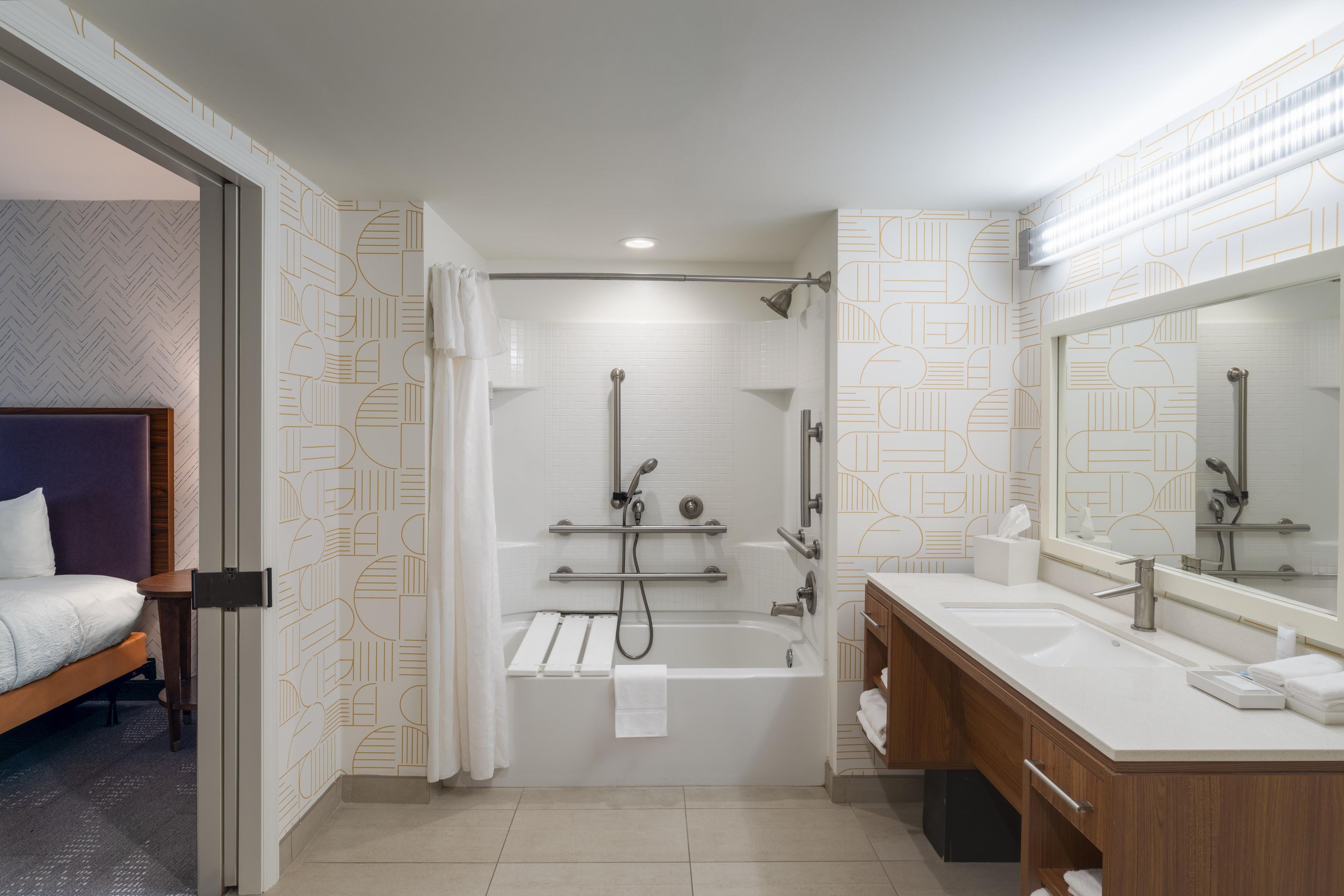A modern bathroom with a bathtub, shower, and dual sinks.
