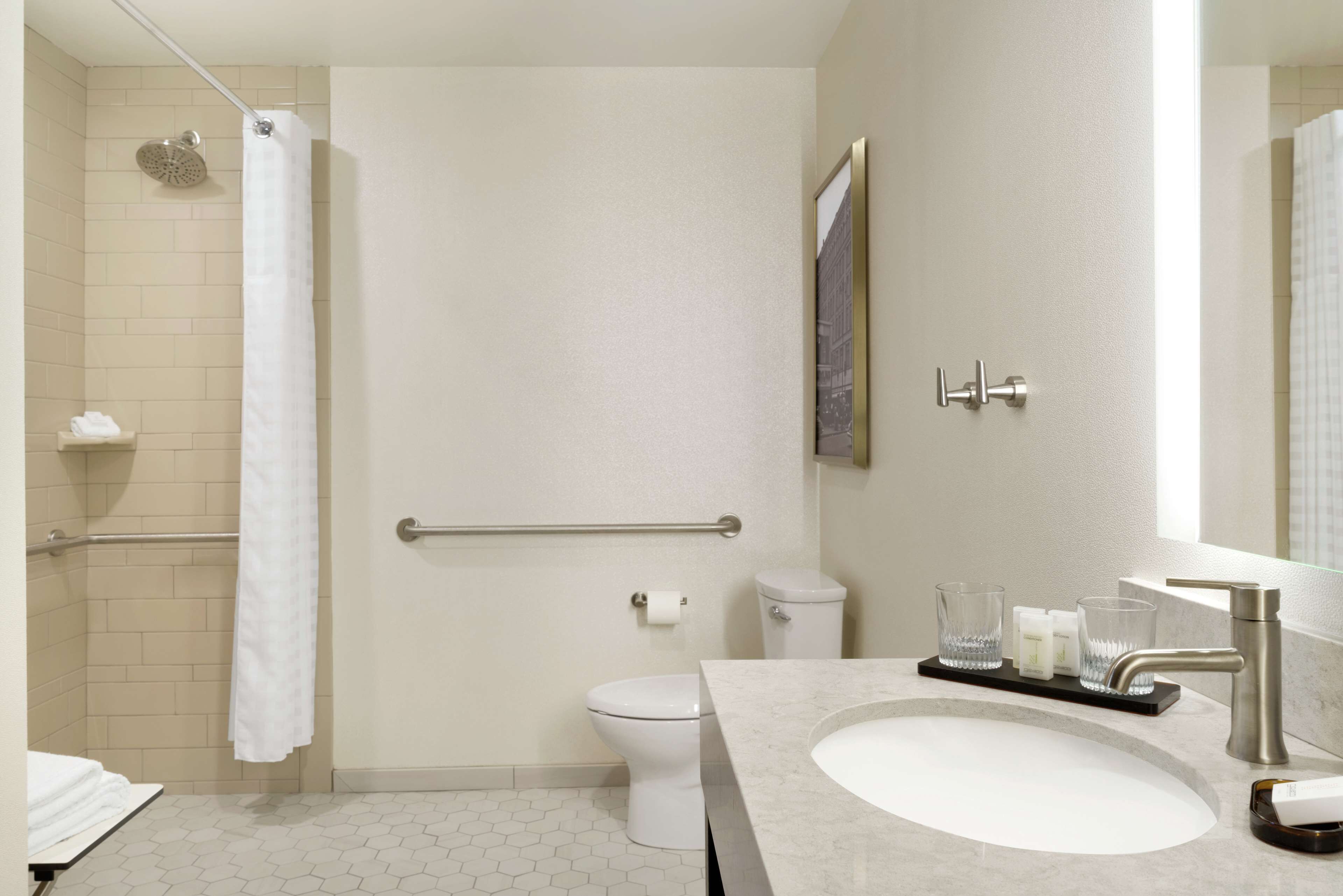 A modern bathroom with a shower, toilet, and sink.