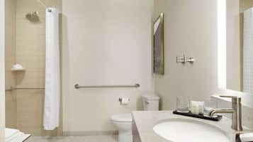 Een moderne badkamer met douche, toilet en wastafel.