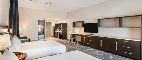 Ein Hotelzimmer mit zwei Betten, einem Schreibtisch, einem Fernseher und einer Minibar.