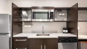 Una cocina moderna con electrodomésticos de acero inoxidable, lavavajillas y horno empotrado.