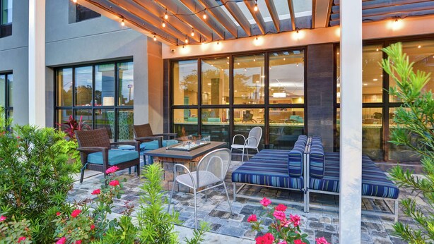 An outdoor patio with seating, a table, and string lights.