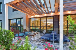 An outdoor patio with seating, a table, and string lights.