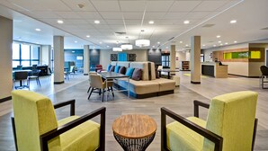 A spacious lobby with a central seating area, a reception desk, and a modern design.