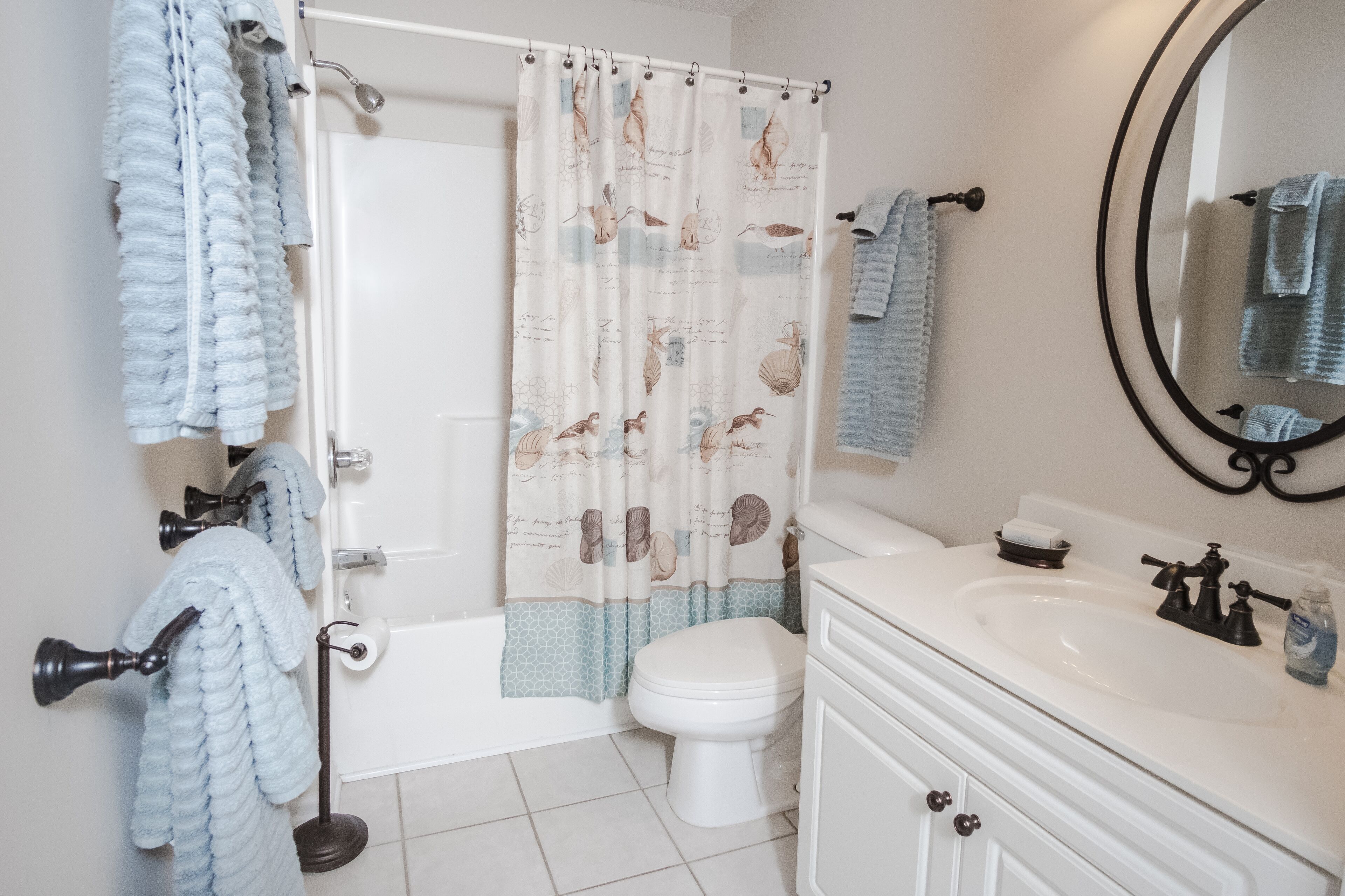 Un baño con bañera, inodoro, lavabo y espejo.