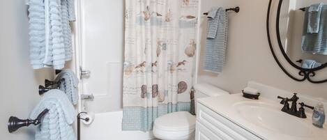 Un baño con bañera, inodoro, lavabo y espejo.