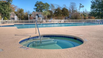 Relax by the pool surrounded by a sandy deck and scenic views.