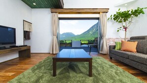 A modern living room with a wooden coffee table, a sofa, and a TV. - Yufuin Tsukahara Villa ERINA (Yufu)