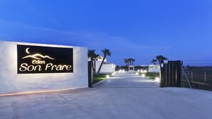 A gated entrance to Eden Son Frere with a signboard, palm trees, and a clear sky. - Villa with detached house, air conditioning, wifi, garden, private swimming pool (Inca)