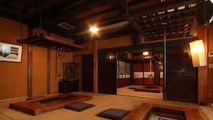 Une pièce de style japonais traditionnel, avec un sol recouvert de tatamis, des meubles en bois et des portes coulissantes.