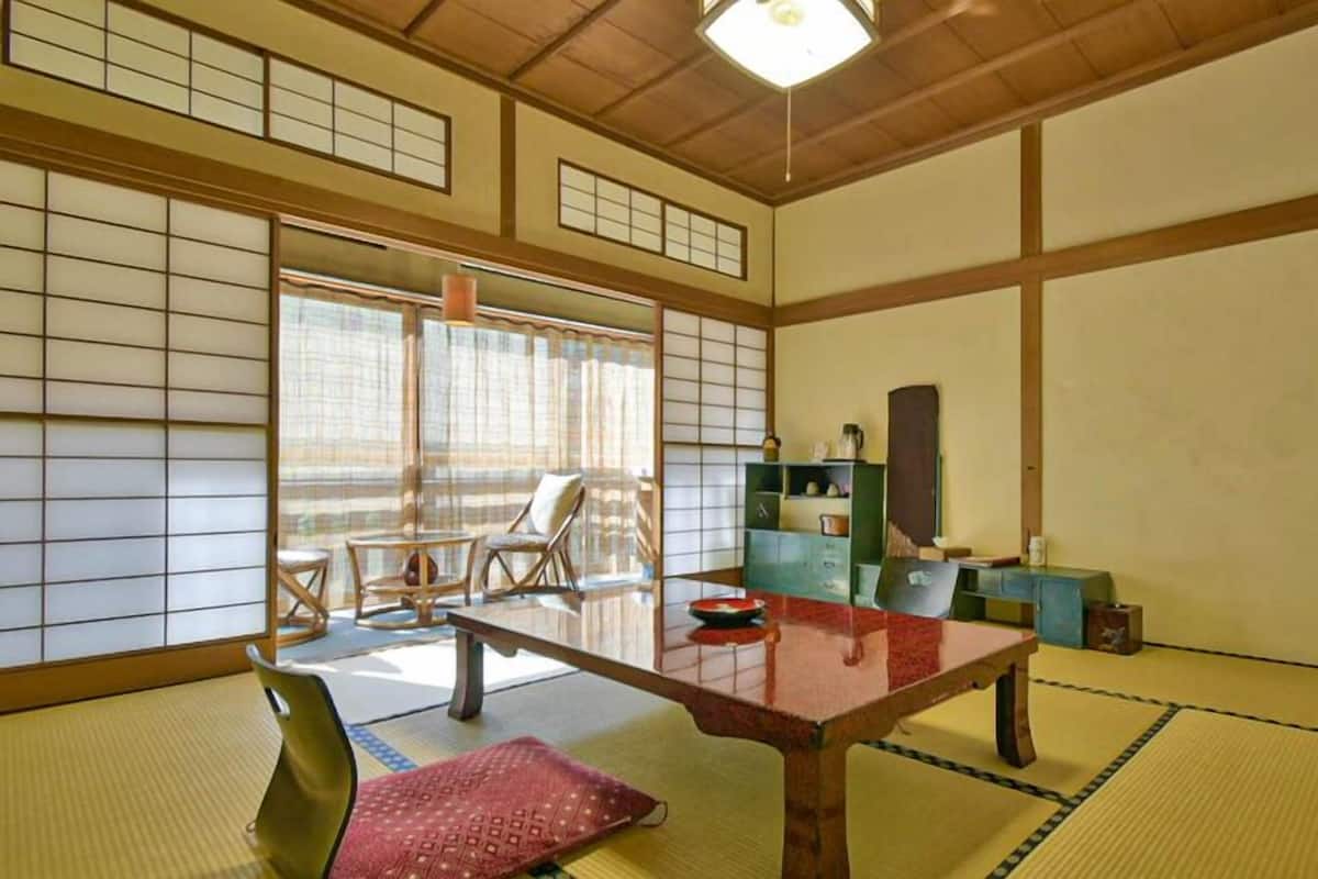 Une pièce de style japonais traditionnel, avec un sol recouvert de tatamis, une table basse et des portes coulissantes.