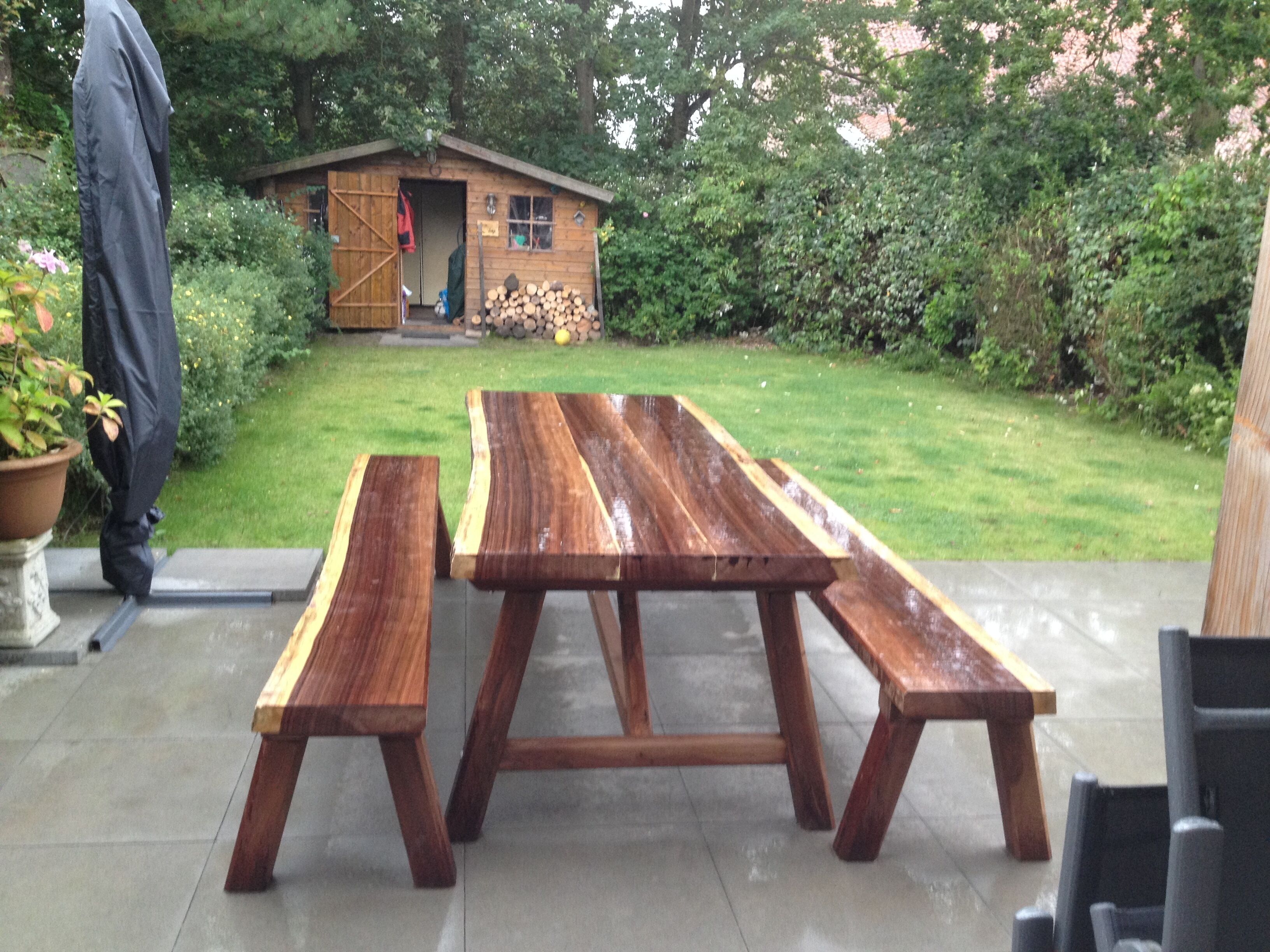 A picnic table with benches in a garden area.