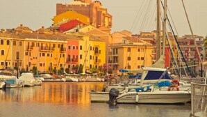 A harbor with colorful buildings and a castle-like structure in the background. - First line of the sea - Port Saplaya (Alboraia)